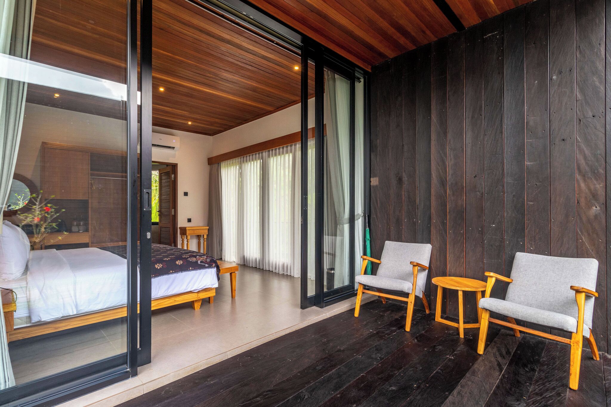 Un dormitorio con una cama, un banco de madera y un sofá.