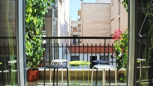 A balcony with a metal railing, potted plants, and outdoor tables and chairs. - Athens SmArt Three-Room Apartment (Athens)
