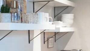 A modern kitchen with a white countertop, stainless steel faucet, and a coffee machine.