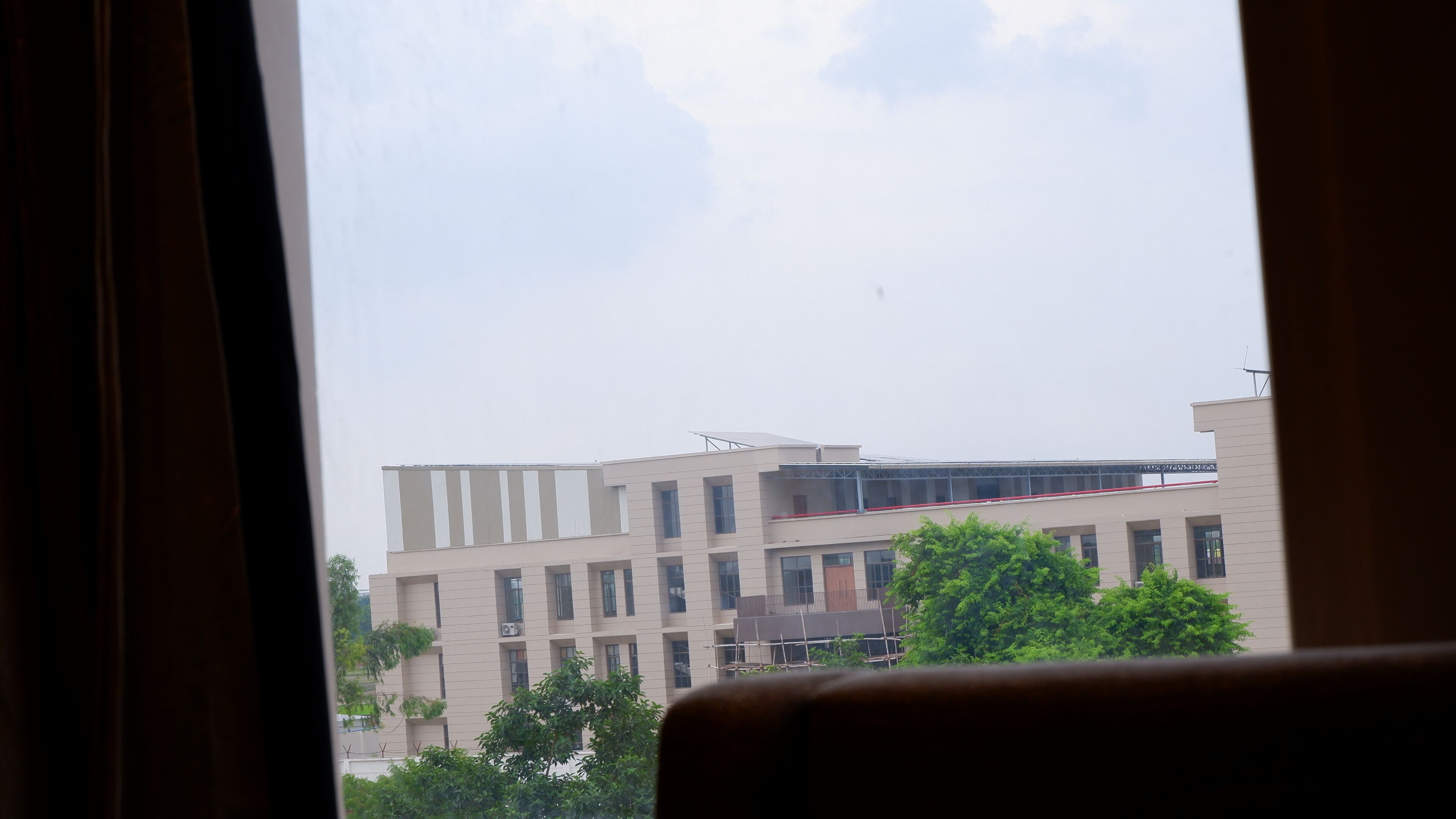 Vista de un edificio de varios pisos con techo plano y balcón.