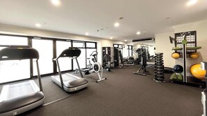 Un gimnàs amb cintes de córrer, el·líptiques, màquines de peses i una varietat de peses lliures.