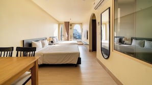 A hotel room with two beds, a dining table, a large window with a city view, and an air conditioning unit. - Weal Apartment (Da Nang)