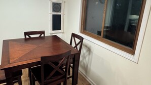 A dining area with a wooden table and chairs, a wall clock, a window, and a ceiling light fixture. - Cozy 3-bedroom house in delightful Superiorwith a Riverview (Superior)