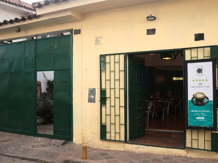 Un edificio con una puerta verde y un letrero que muestra una taza de café y estrellas.