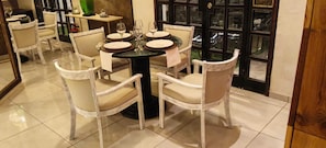 Un comedor con una mesa redonda, sillas y vistas a través de un ventanal.