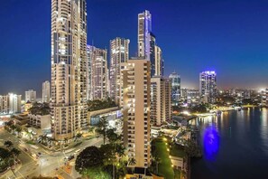 A high-rise building complex with multiple residential towers, a waterfront, and a well-lit urban environment. - Salt & Sky Arcade - Sleeps 12 (Surfers Paradise)