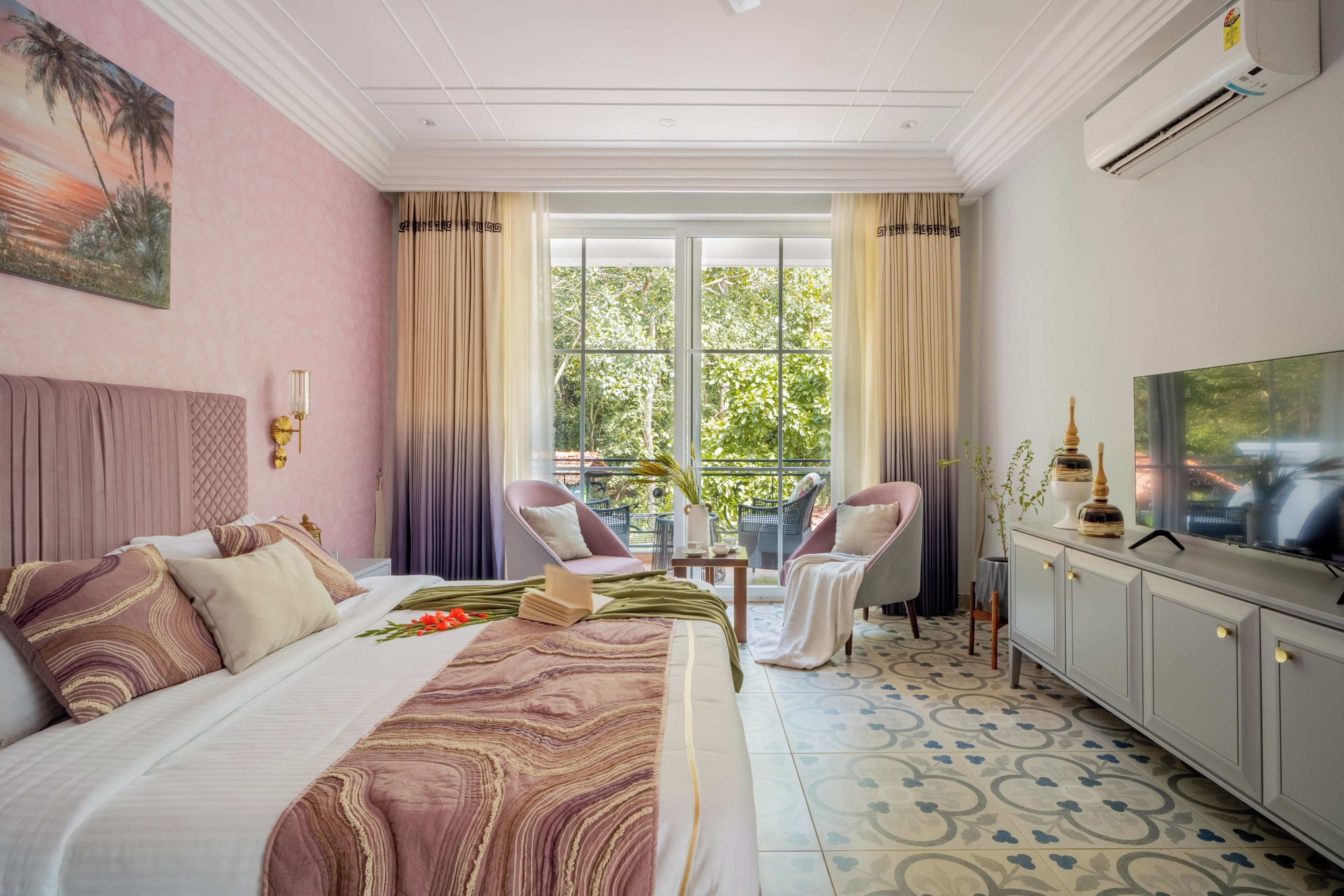 Una habitación de hotel con cama, televisión, balcón con sillas y un ventanal grande.