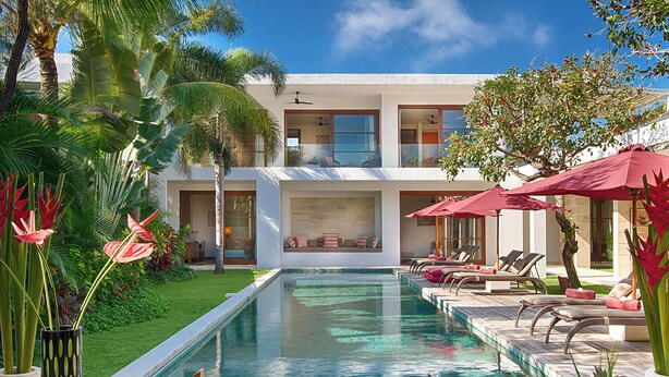 A pool with a wooden boat-shaped feature, lounge chairs, and umbrellas. - Casa Brio Bali (Seminyak)