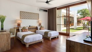 A hotel room with two beds, a desk, a ceiling fan, and a view of the outdoor area. - Casa Brio Bali (Seminyak)