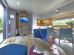 A modern interior with a television, seating area, and a kitchenette.