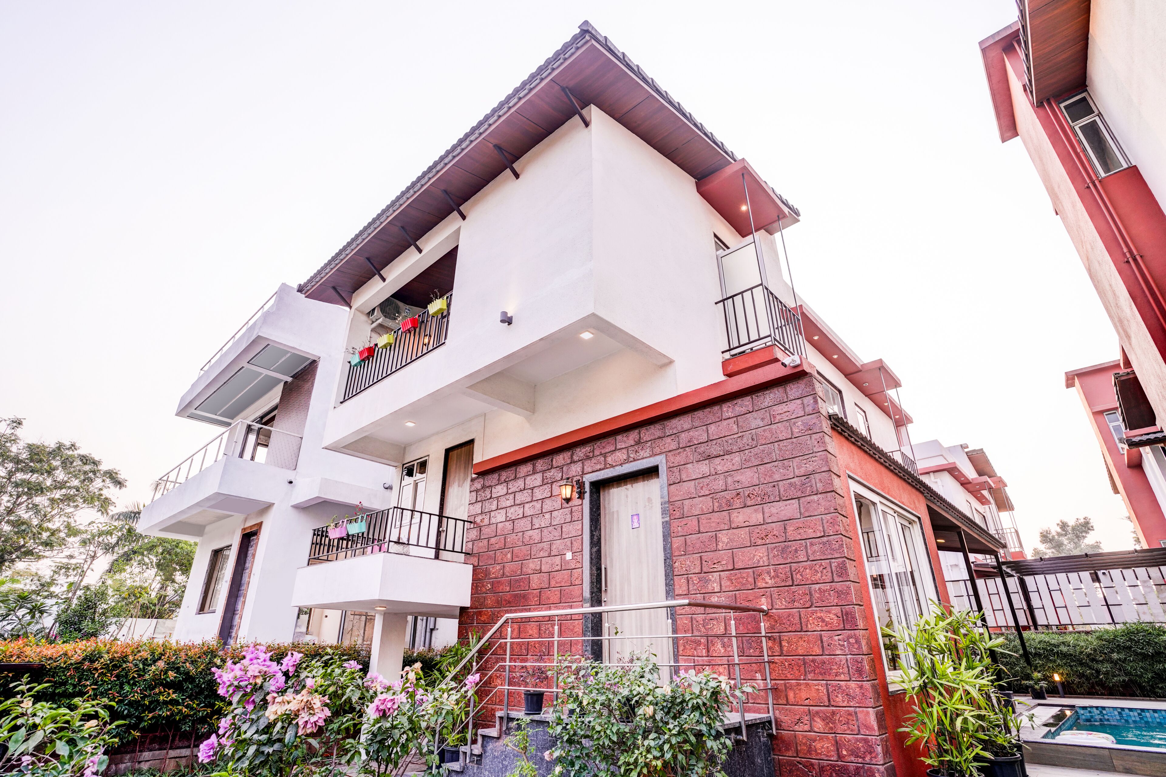 A multi-story residential building with balconies, a swimming pool, and a brick facade.