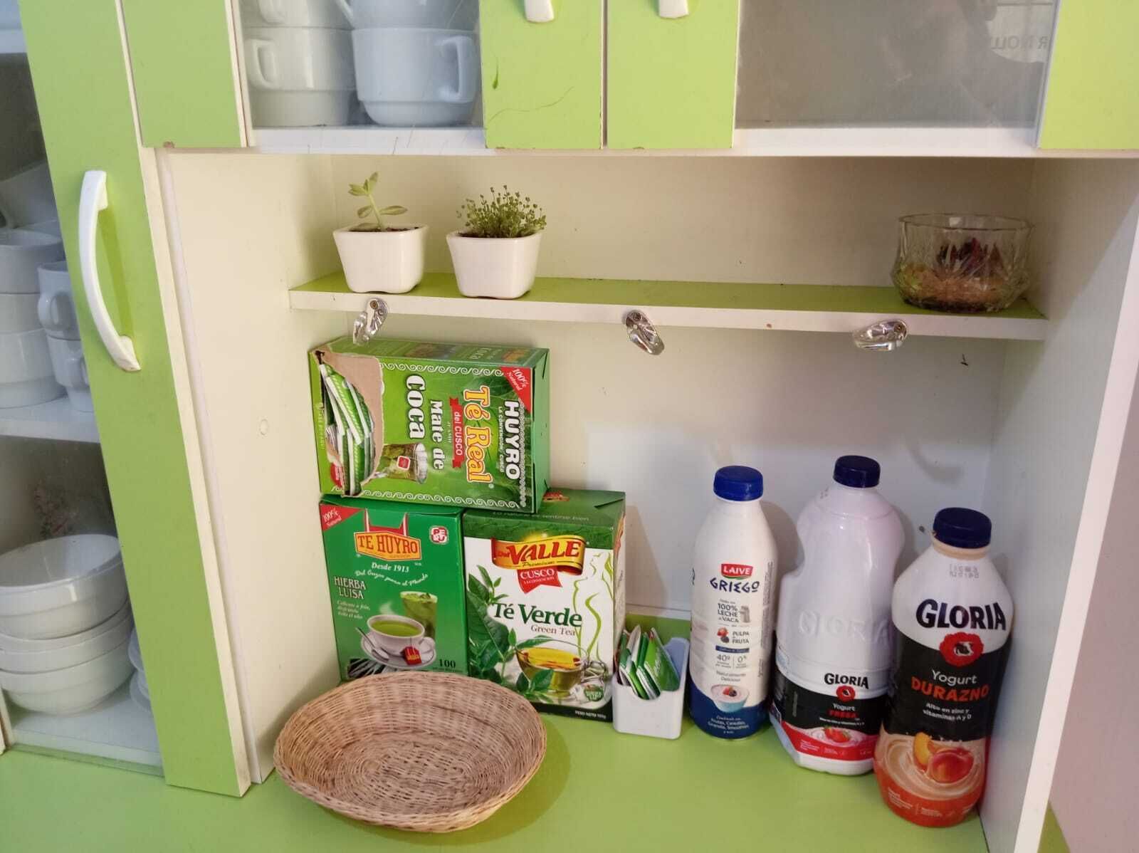Un armario de cocina con diversos productos alimenticios, incluyendo cajas de té Huyro, té verde Vallee y yogur Gloria.