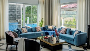Un amplio salón con un sofá azul grande, una mesa de centro y una chimenea.
