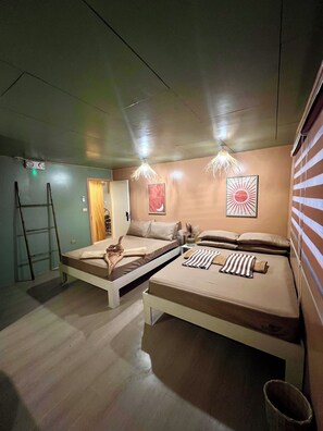 A room with two beds, a ladder, a wall-mounted light fixture, and a framed picture.