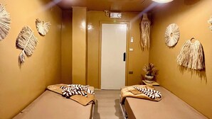 Une chambre avec deux lits, une porte et des décorations murales.