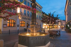 A square with a central fountain, benches, and a building with signage. - Vacation apartment in the Marktstraße (Teisendorf)