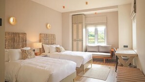 A hotel room with two beds, a small table, a sofa, and a window with a view. - Stone Heaven Villa (Nuwara Eliya)