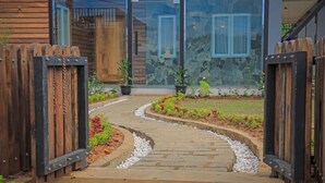 A pathway leading to a building with a stone facade and wooden gates. - Stone Heaven Villa (Nuwara Eliya)