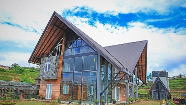 A modern house with a sloped roof, large windows, and a stone facade. - Stone Heaven Villa (Nuwara Eliya)