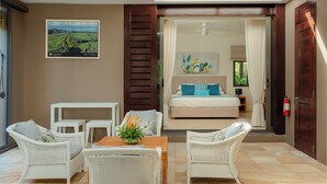 Ein Schlafzimmer mit einem Bett, einem Fenster mit Vorhängen, einem Gemälde und Blick auf eine Landschaft.
