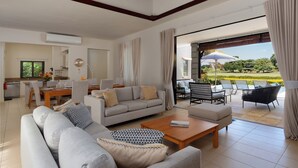 Ein geräumiger Wohnbereich mit Sofa, Couchtisch und Esstisch.