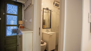 A bathroom with a toilet, sink, and a mirror above the sink. - Casa Nora in Centre of Vodnjan (Vodnjan)