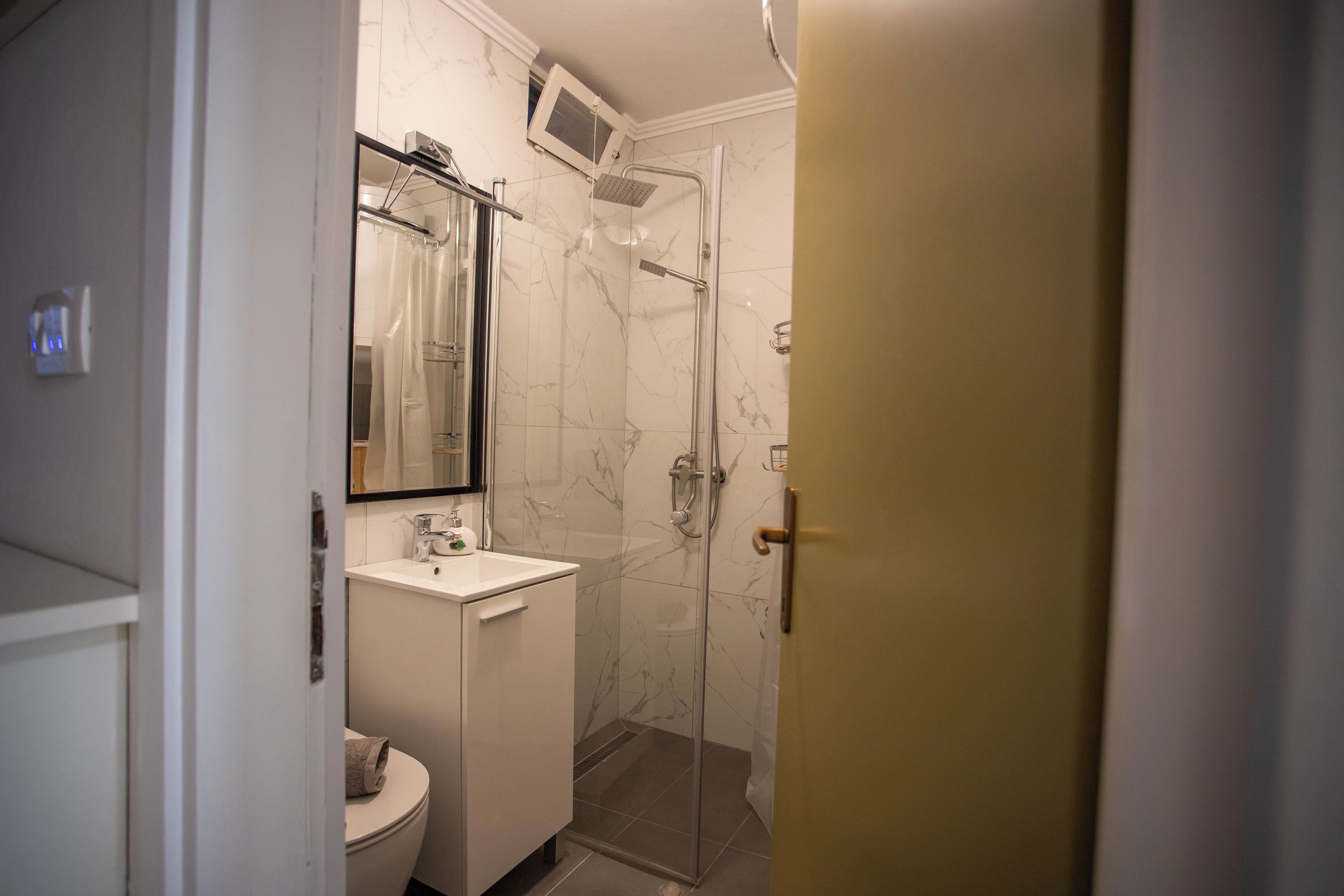 A bathroom with a shower, toilet, and sink.
