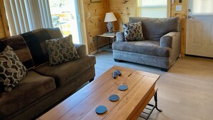 A wooden interior with two sofas, a coffee table, and a lamp. - 3-bedroom cabin in Madisonville TN (Madisonville)