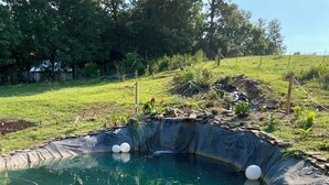 A clear swimming pool with a wooden deck and surrounding rocks. - 3-bedroom cabin in Madisonville TN (Madisonville)