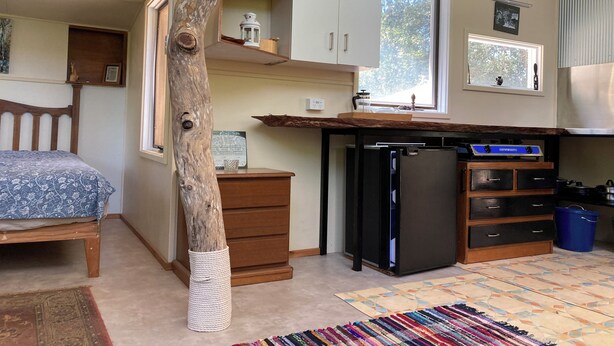 A compact kitchen with a refrigerator, wooden cabinets, and a window. - MOUNTAIN (BALGARR) CABIN RETREAT (Not quite glamping, perfect getaway) (Elands)
