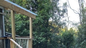 A wooden deck with steps leading to a covered area, surrounded by a gravel path with stepping stones and a brick border. - MOUNTAIN (BALGARR) CABIN RETREAT (Not quite glamping, perfect getaway) (Elands)