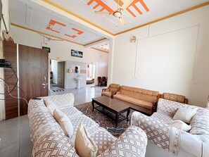 Un salon comprenant un ensemble de canapés, une table basse et un ventilateur de plafond.