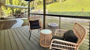 An outdoor patio with wicker furniture, a stone fire pit, and a view of a landscaped garden. - Serene 4 bedroom house with AC in charming Tacoma (Tacoma)
