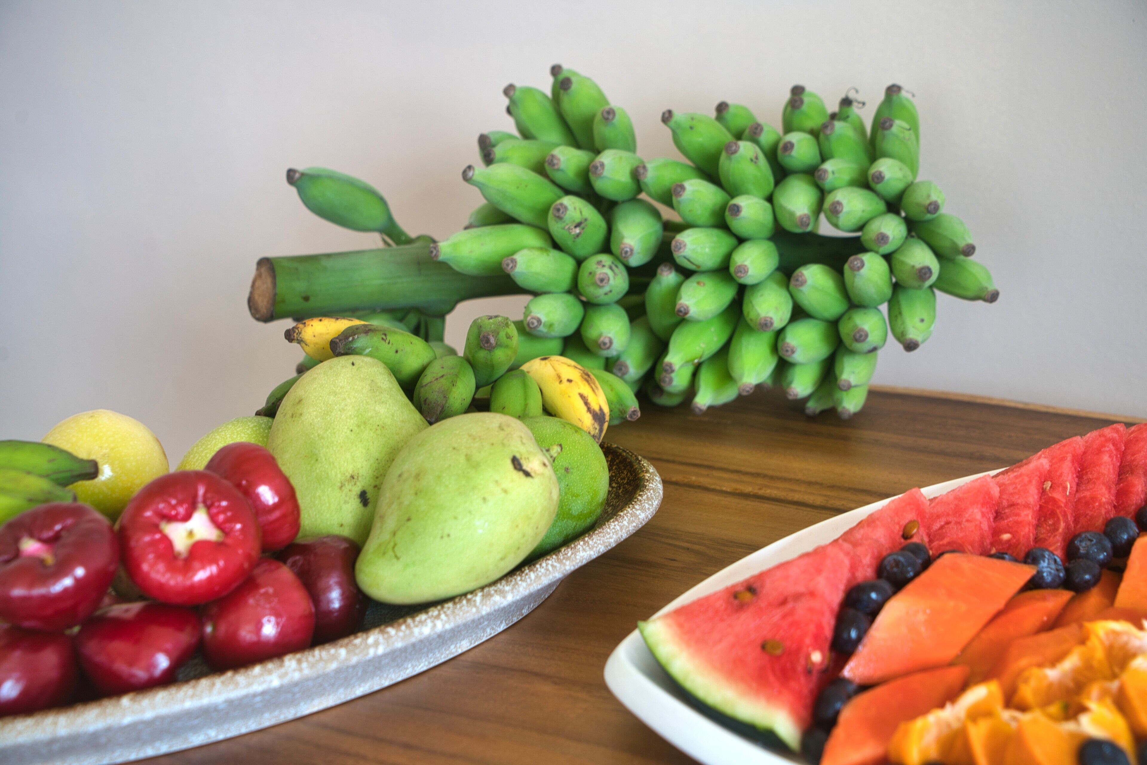 A table with various fruits including bananas, apples, pears, and watermelon.