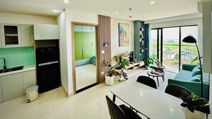Un apartamento moderno con cocina, comedor y sala de estar, con un gran ventanal.