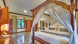 A spacious room with a large bed, a wooden wardrobe, and a window with curtains. - Villa Hibiscus Sanur by Nagisa Bali (Denpasar)