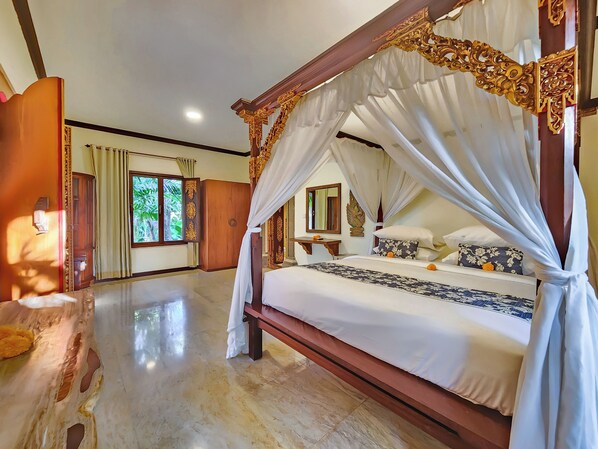 Una habitación amplia con una cama grande, un armario de madera y una ventana con cortinas.