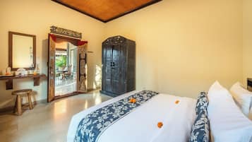 Ein Hotelzimmer mit Bett, Spiegel, Kleiderschrank und Schreibtisch mit Stuhl.
