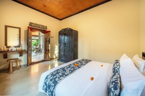 A hotel room with a bed, a mirror, a wardrobe, and a desk with a chair. - Villa Hibiscus Sanur by Nagisa Bali (Denpasar)