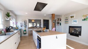 Une cuisine moderne dotée d’un îlot central, d’appareils électroménagers intégrés et d’une cheminée.