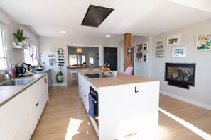 A modern kitchen with a central island, built-in appliances, and a fireplace.