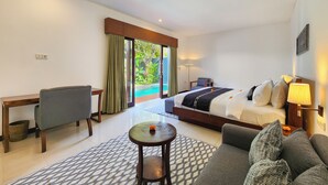 A hotel room with a bed, a sofa, a desk, a chair, and a view of a swimming pool. - Villa Movida Canggu by Nagisa Bali (Kerobokan)