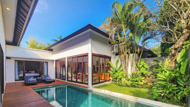 A modern house with a swimming pool, wooden deck, and lush greenery. - Villa Movida Canggu by Nagisa Bali (Kerobokan)
