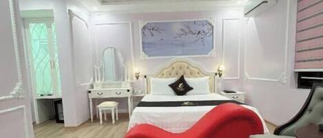 A bedroom with a bed, a desk, a chair, and a window.