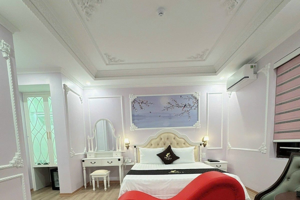 A bedroom with a large bed, a desk, and a chair.