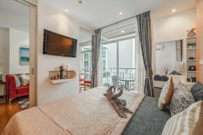 A hotel room with a bed, a TV, a balcony with a table and chairs, and a view of the outside. - Patong City No Deposit Or Extra Charges C211 (Pa Tong)