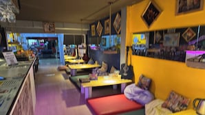 Un restaurant avec des banquettes, des tables et un comptoir.
