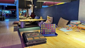 Un restaurant chaleureux avec une table en bois, des coussins et un jeu de société.