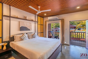 Un dormitorio con cama, ventilador de techo, un cuadro y vistas a una piscina y zona exterior.