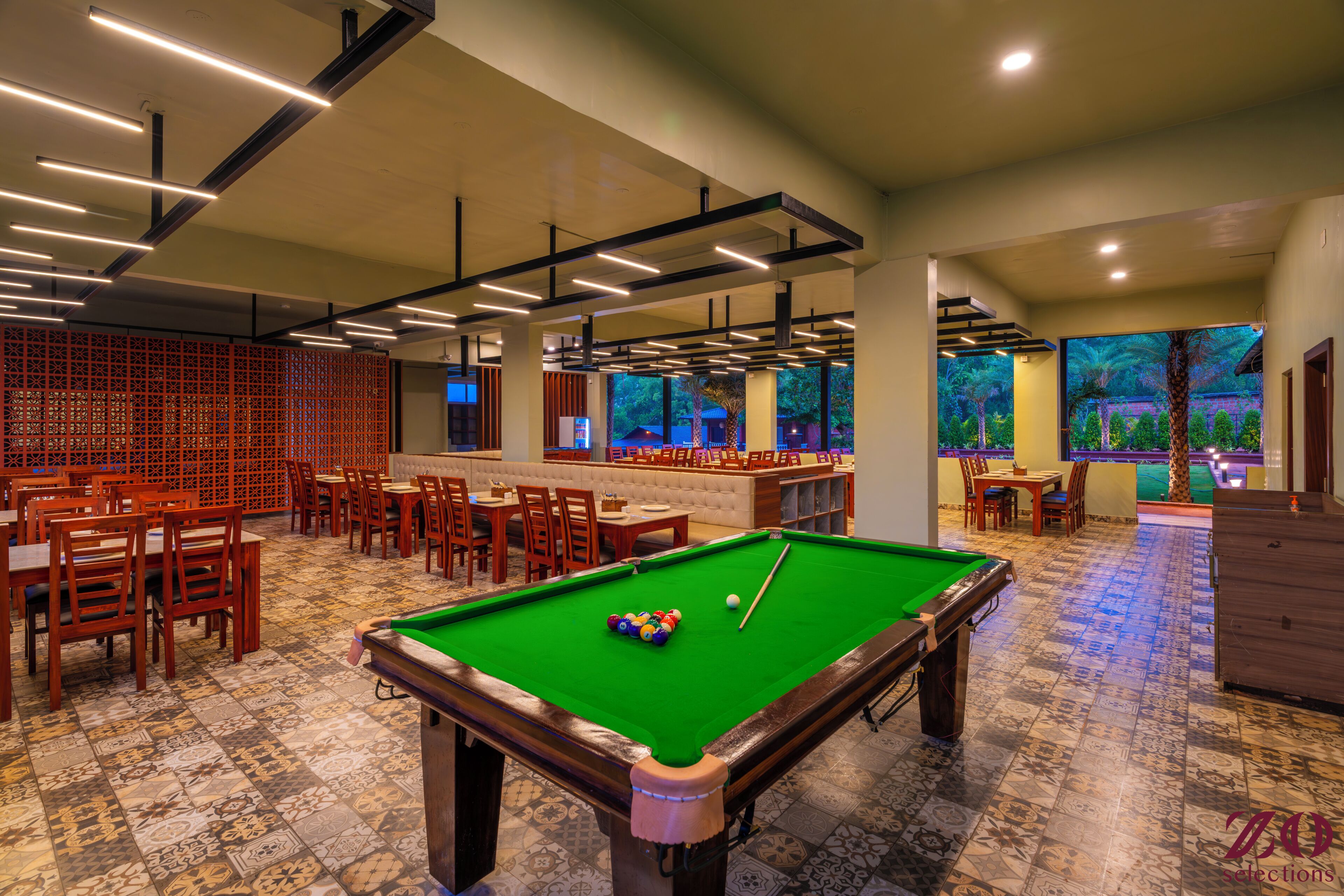 Ein Billardtisch mit Kugeln, eine Lounge-Ecke mit Stühlen und Tischen.
